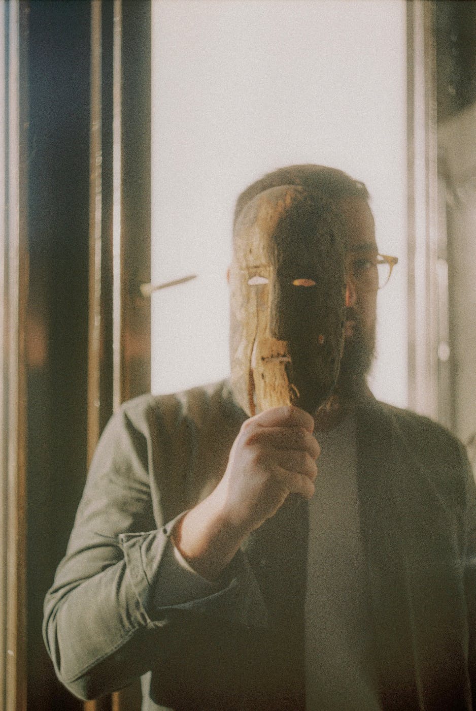 A man covering half his face with a mask