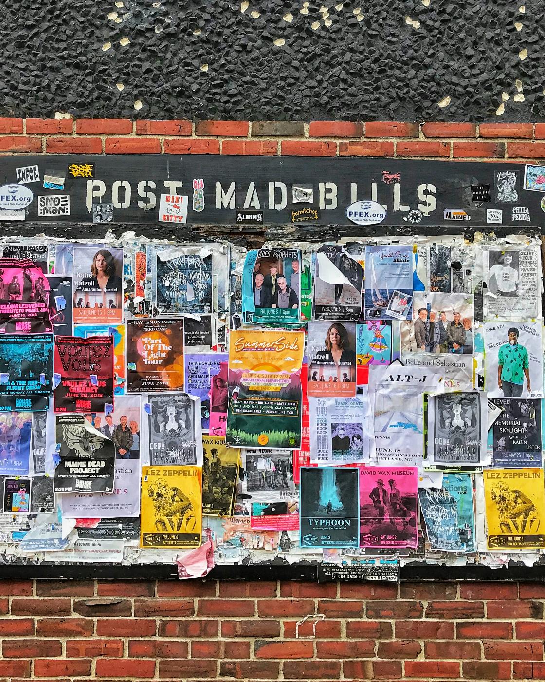 a wall with Post Mad Bills and hundreds of bills posted