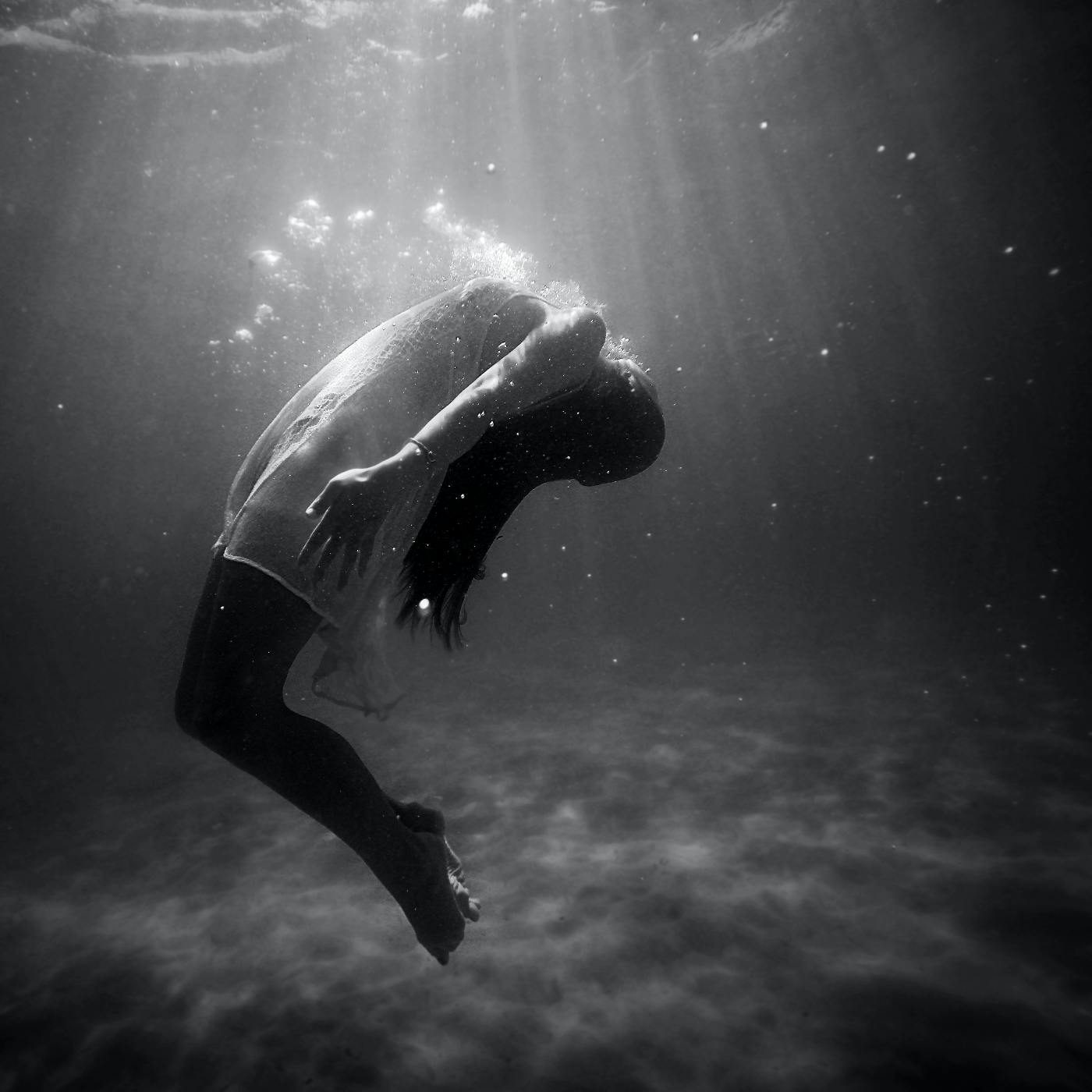 A woman in a white shift underwater