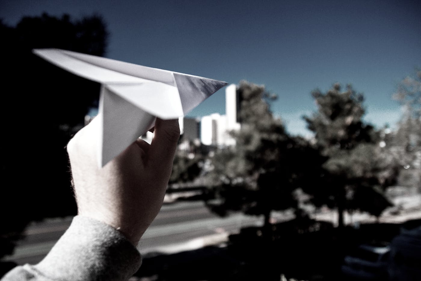 A hand with a paper airplane about to be thrown.