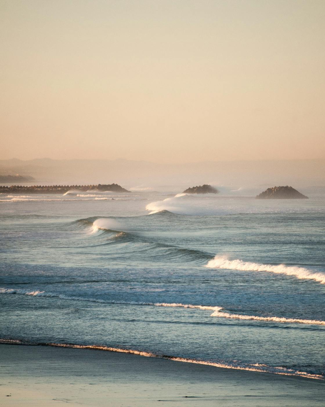 A line of waves headed toward a beach