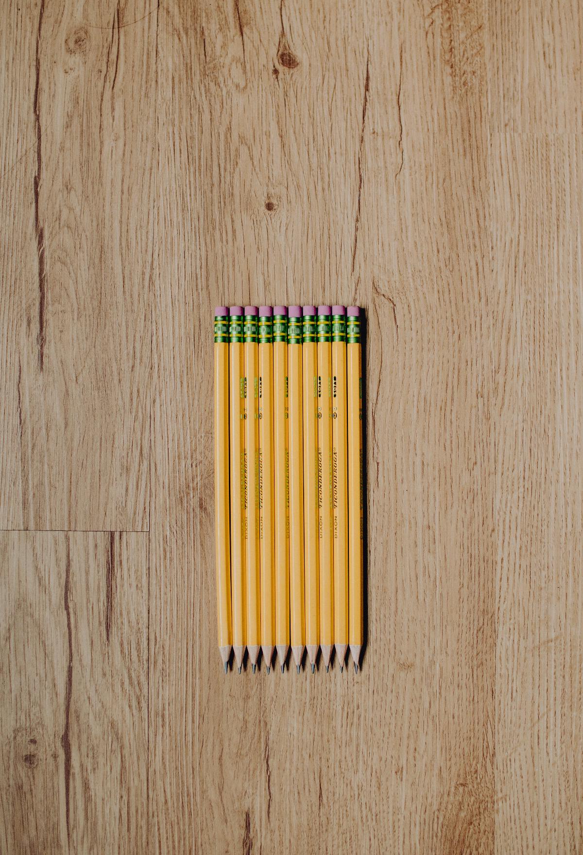 ten neatly lined up number 2 pencils on a wood surface.
