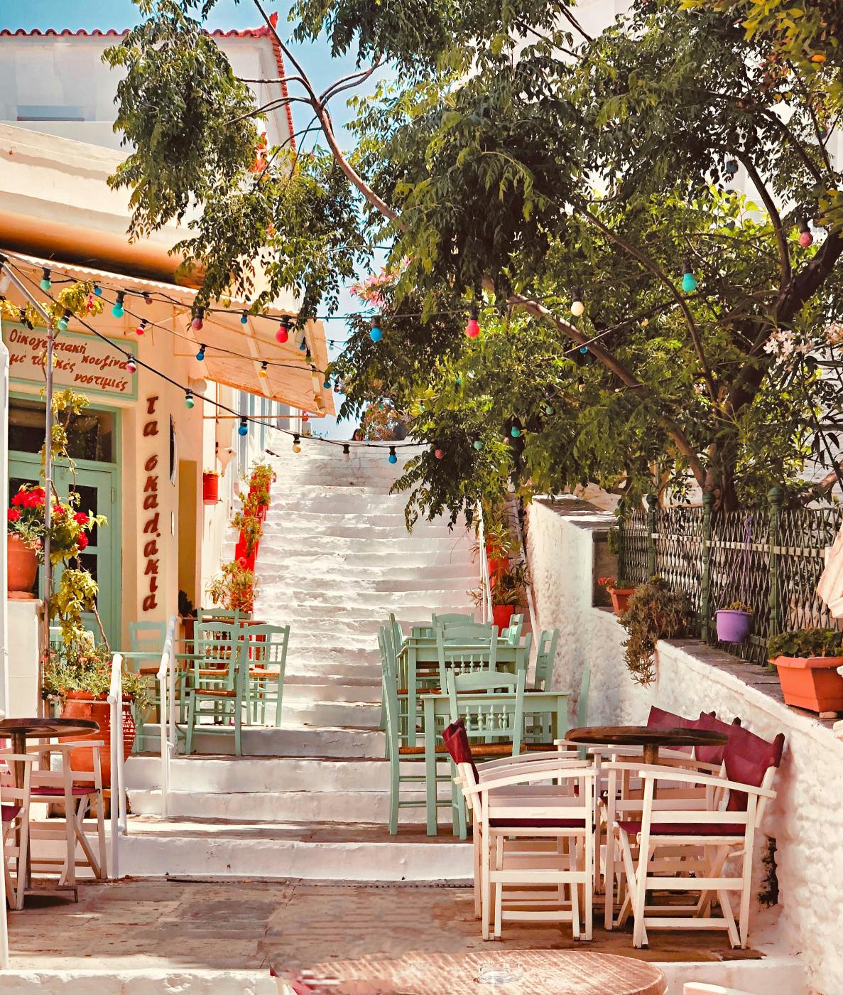 A restaurant patio with wood chairs and trees in the afternoon