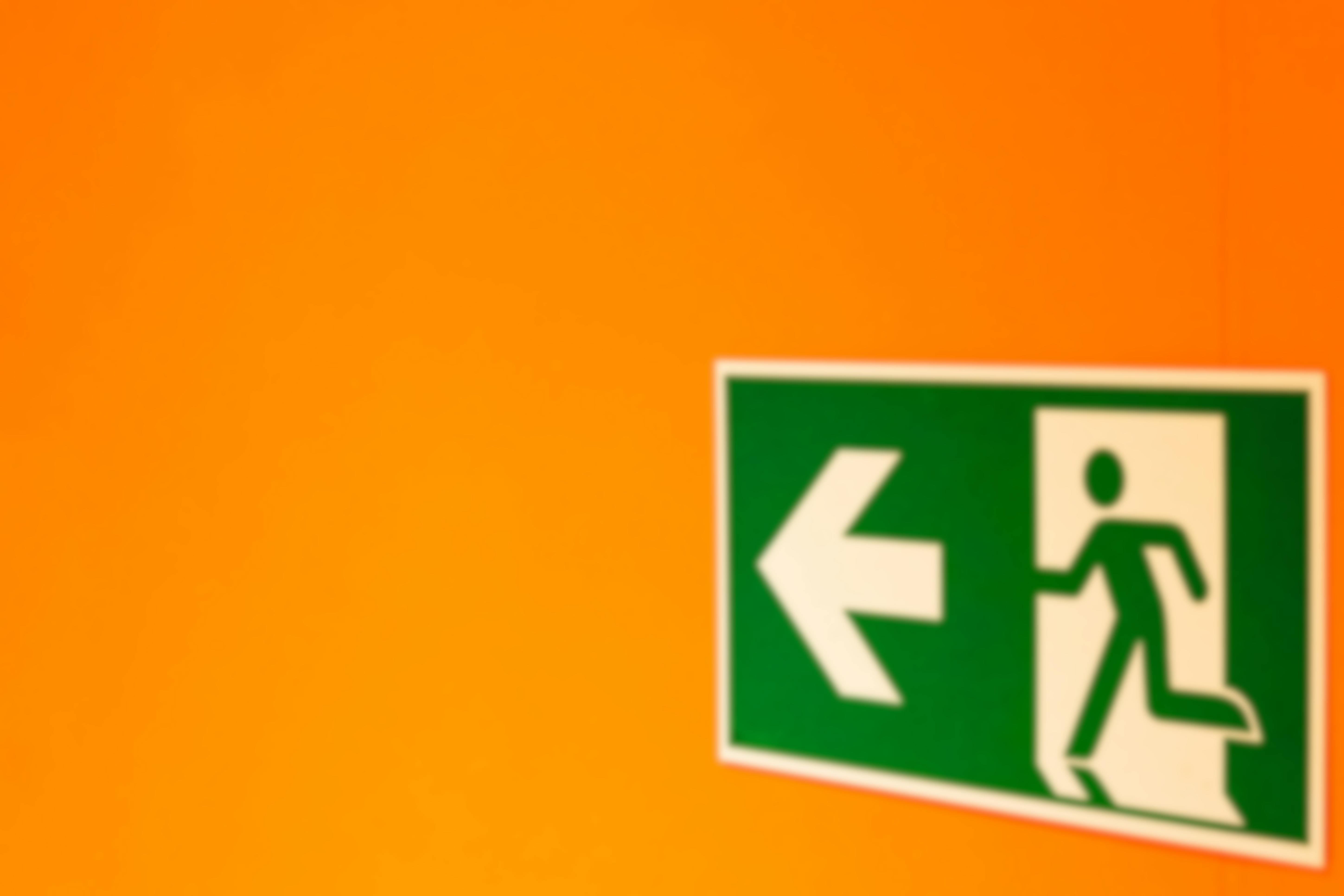 green exit sign on orange wall