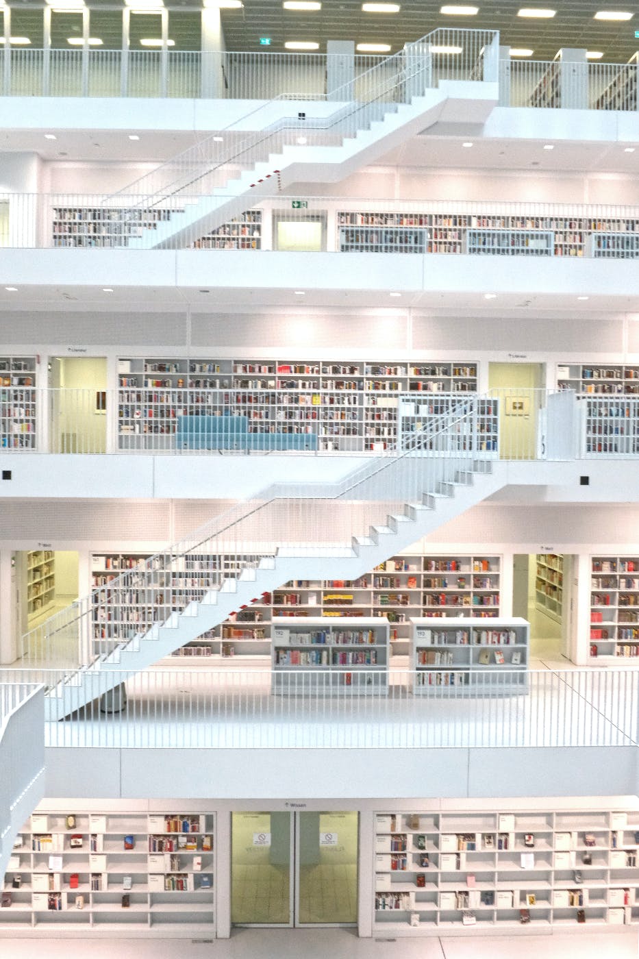four floors of a library with white walls and stairs