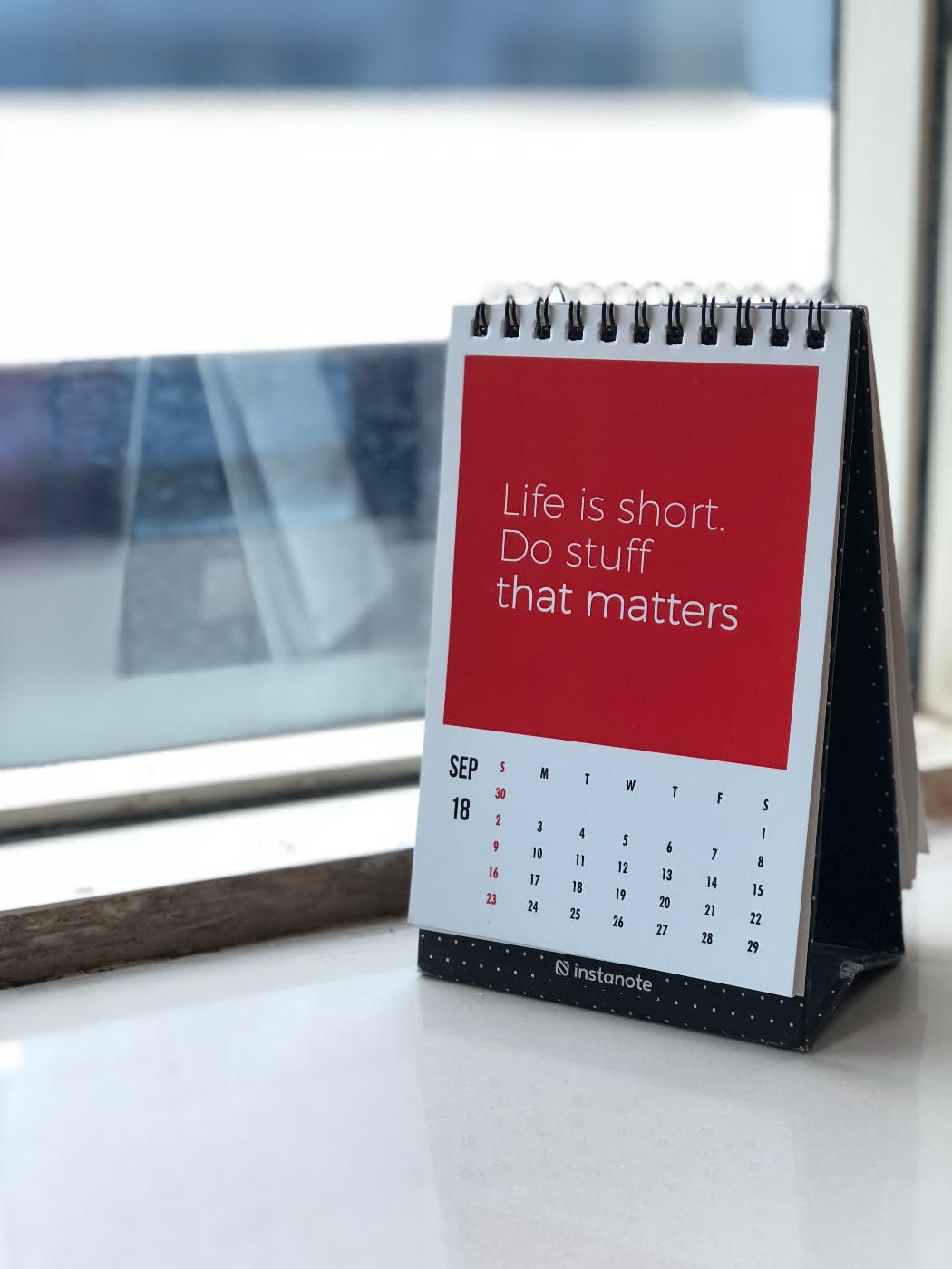 a desk calendar on a window sill with the words Life is Short, Do Stuff that Matters