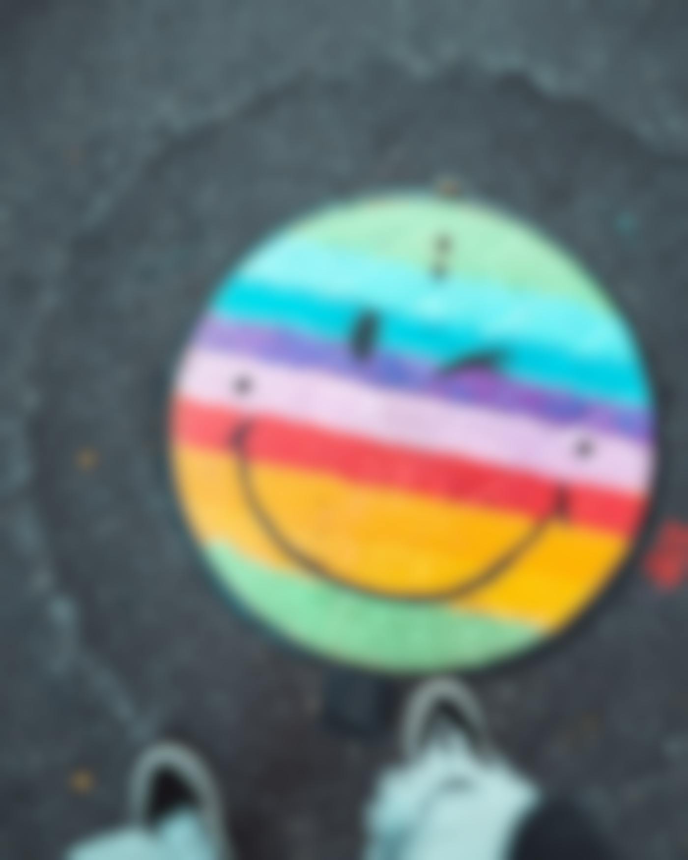 A manhole covered painted with a smiley face.