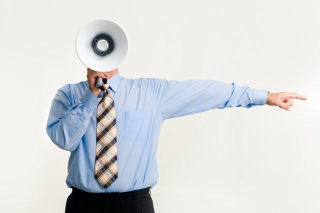 man in suit and tie with a megaphone 