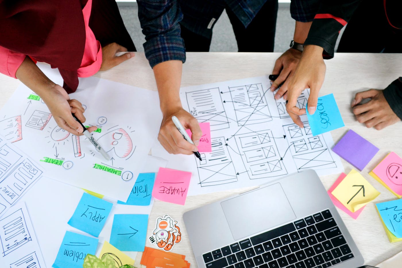 a group around a table working on a sketch of an interface