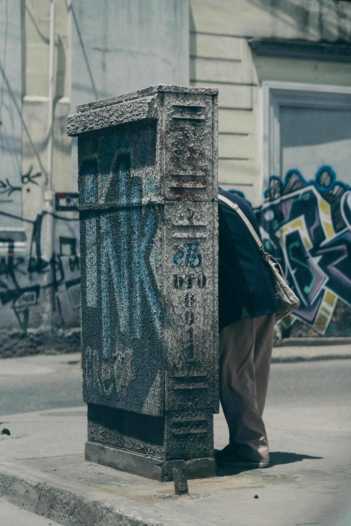 A man hiding behind a concrete wall