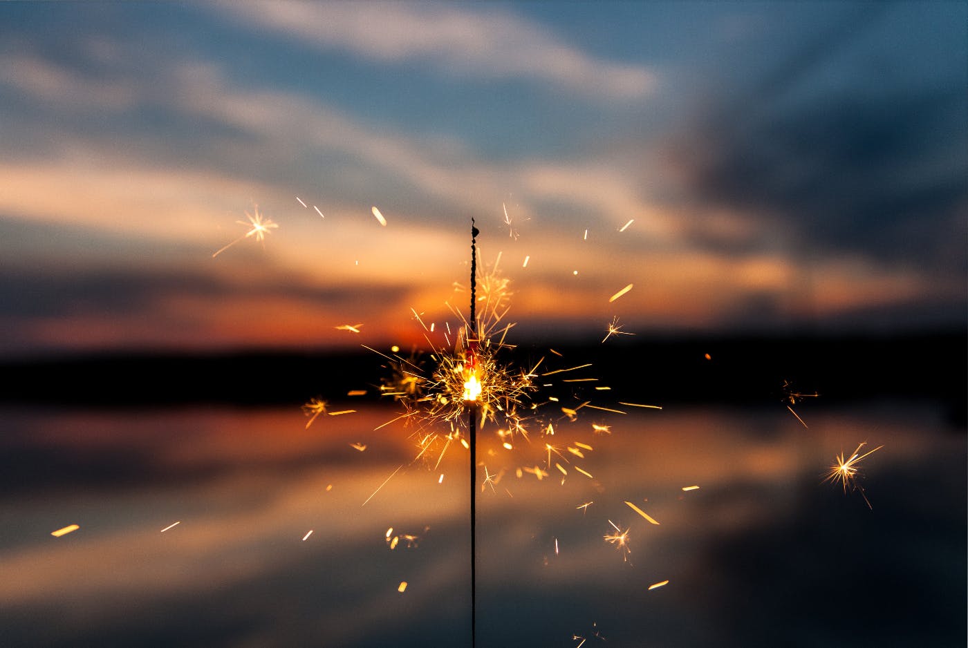 A half burned sparkler against a setting sun