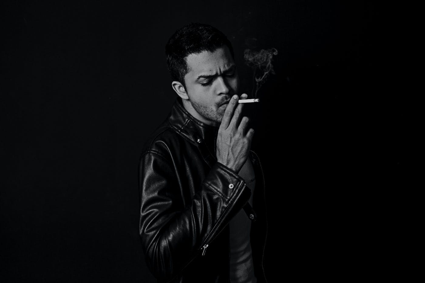 A man in a leatehr jacket smoking a cigarette by Lucas Filipe