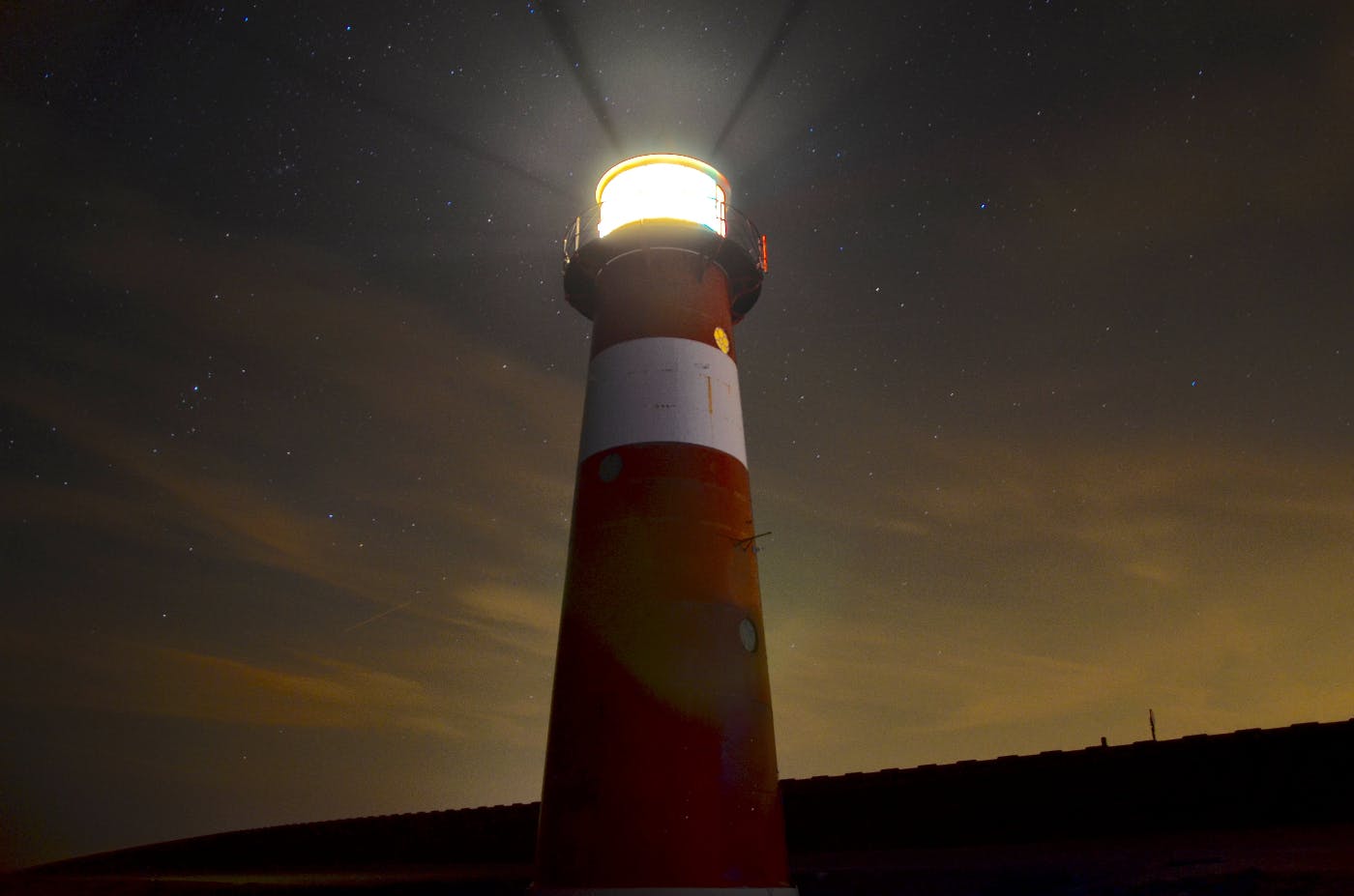 A low angle shot of a red and white lighthouse