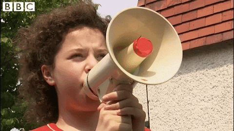 girl with megaphone yelling attention please