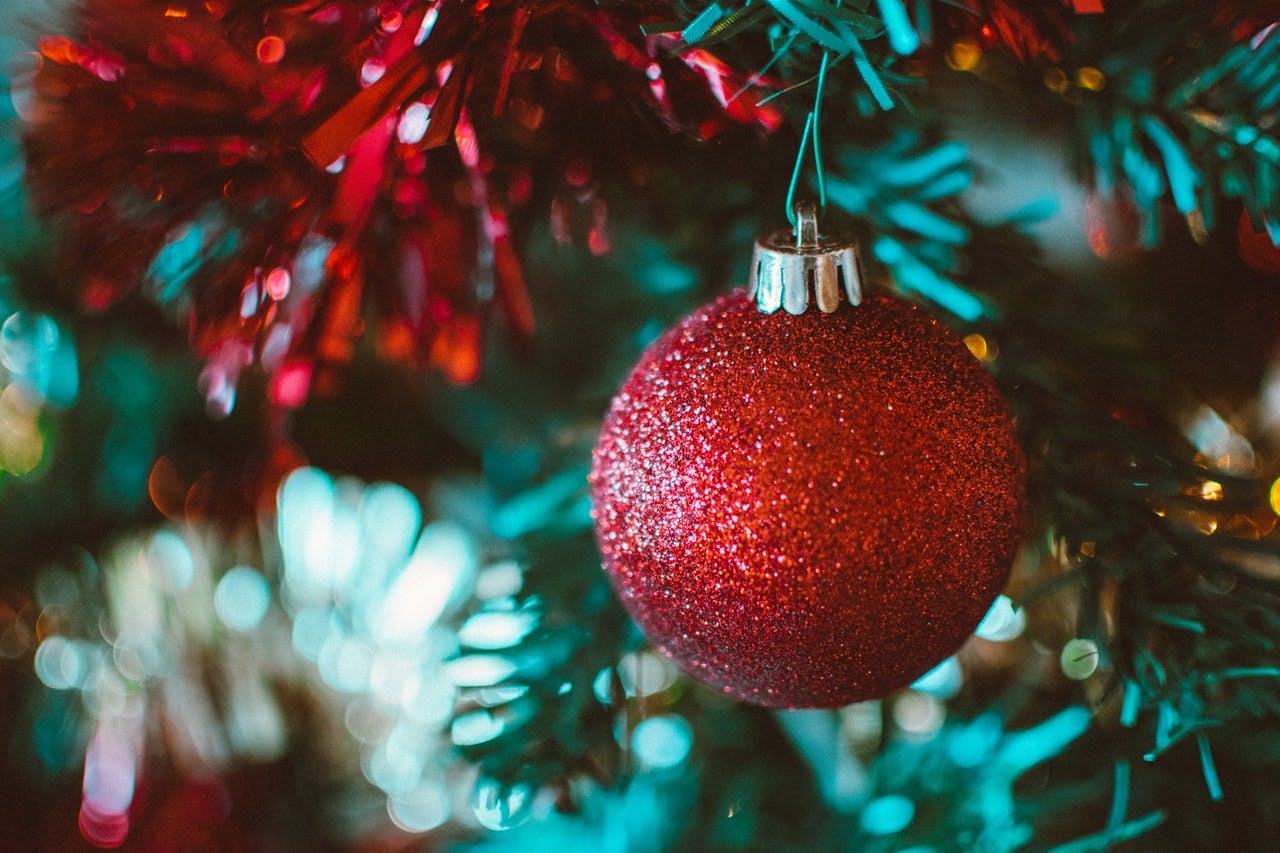 red sparkly Christmas ornament hanging in tree