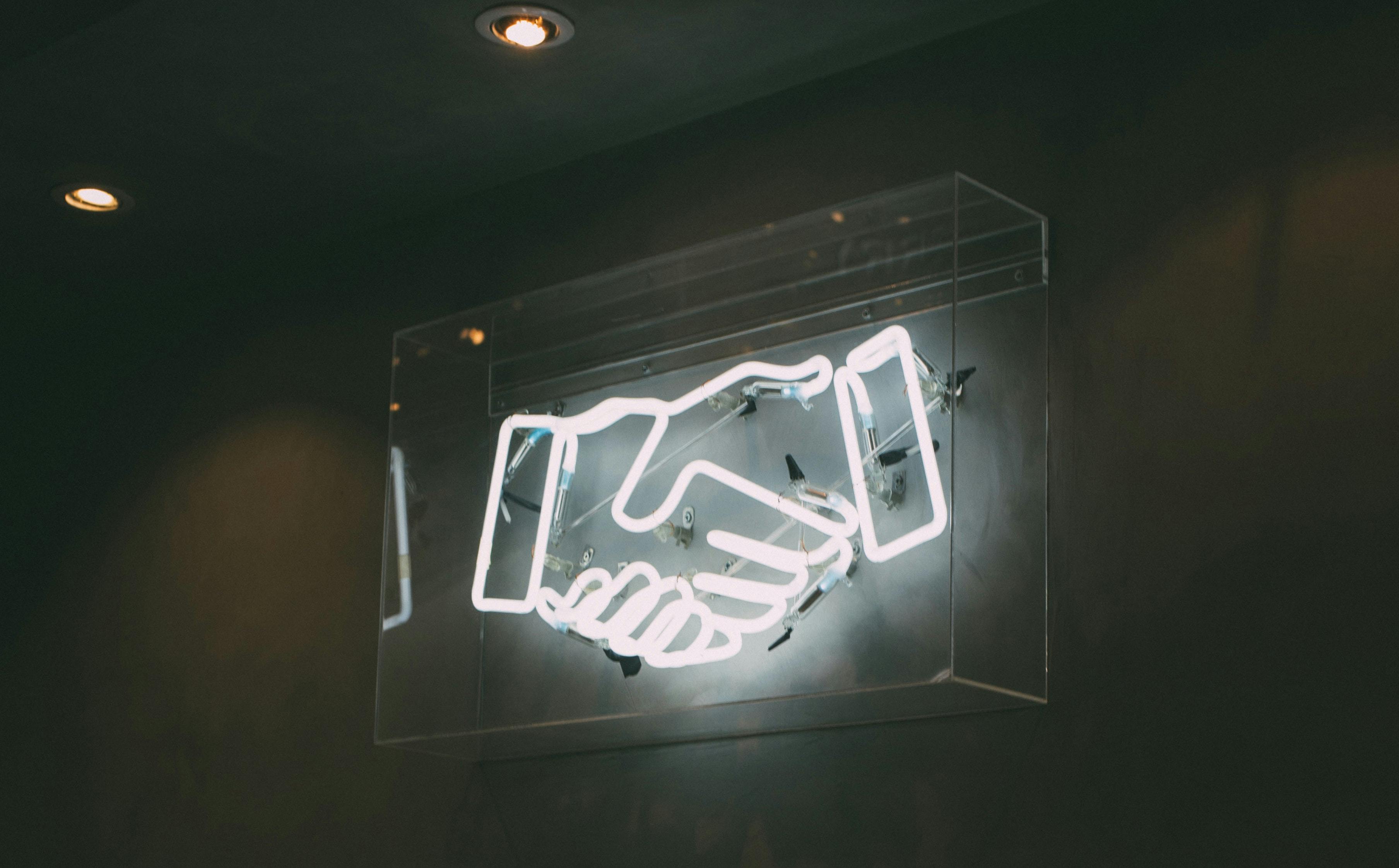 neon sign of shaking hands