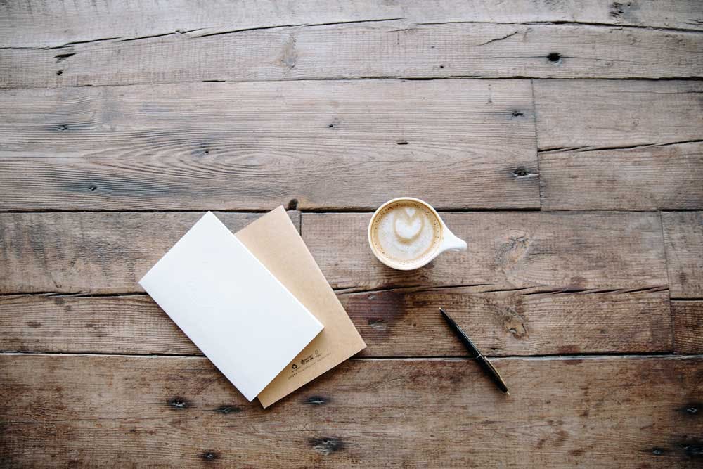 an envelope, letter and cup of coffee shot from above