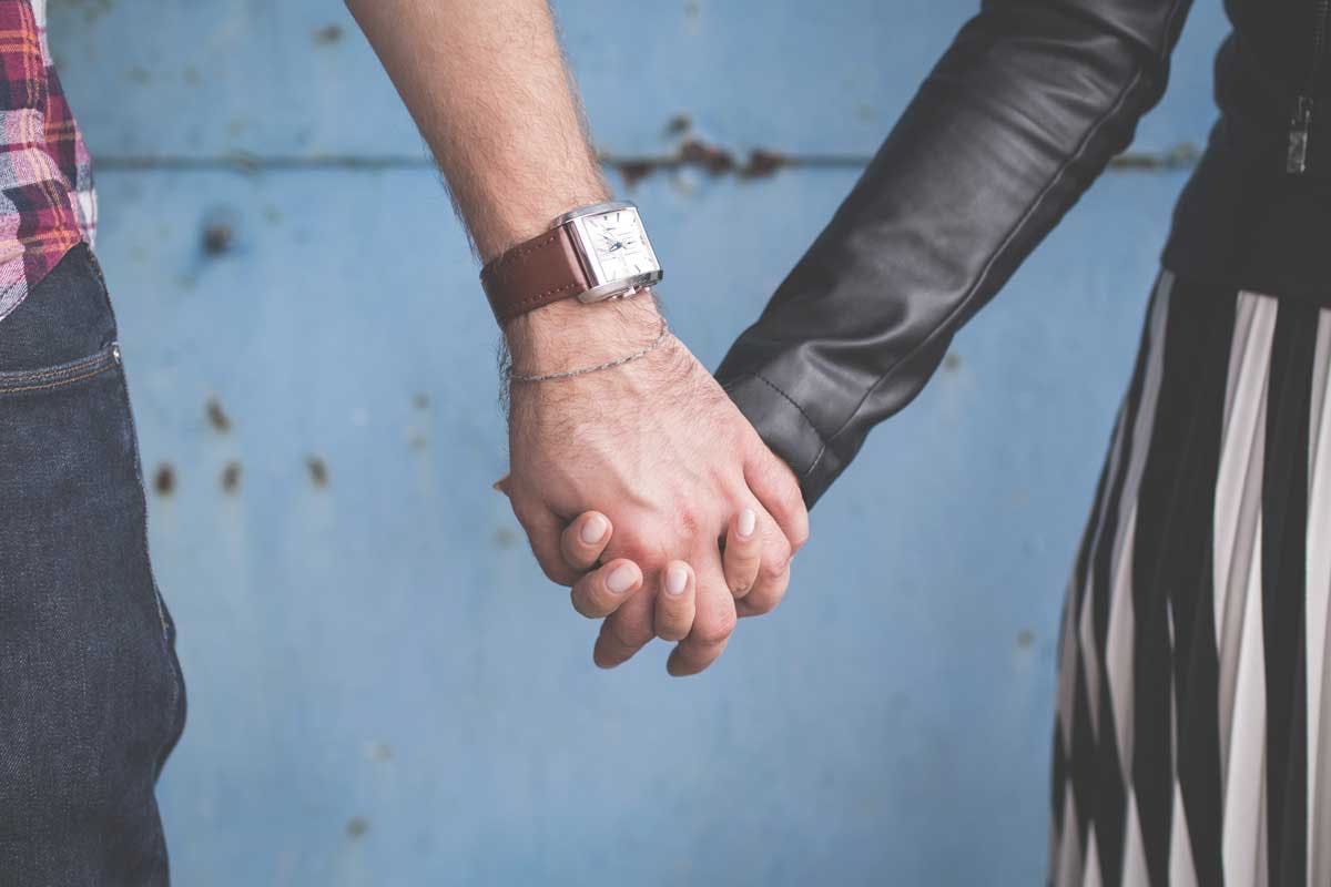 close up of man and women holding hands