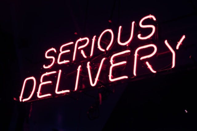 neon sign reading serious delivery