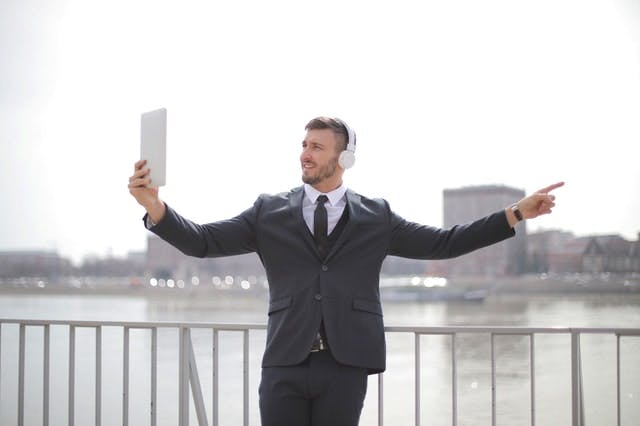 man in suit having zoom meeting on ipad