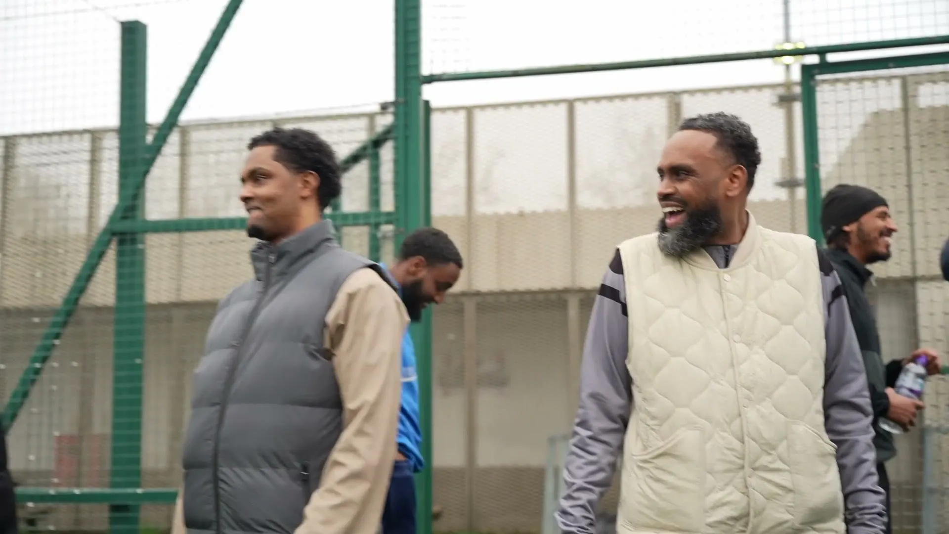 Two men laughing on the touchline at the Onside tournament