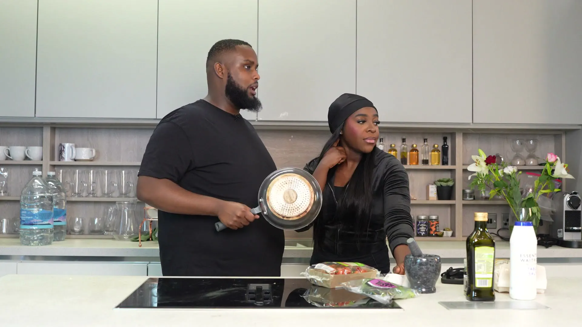 A host and a guest talking in the kitchen on the set of Behind The Stove