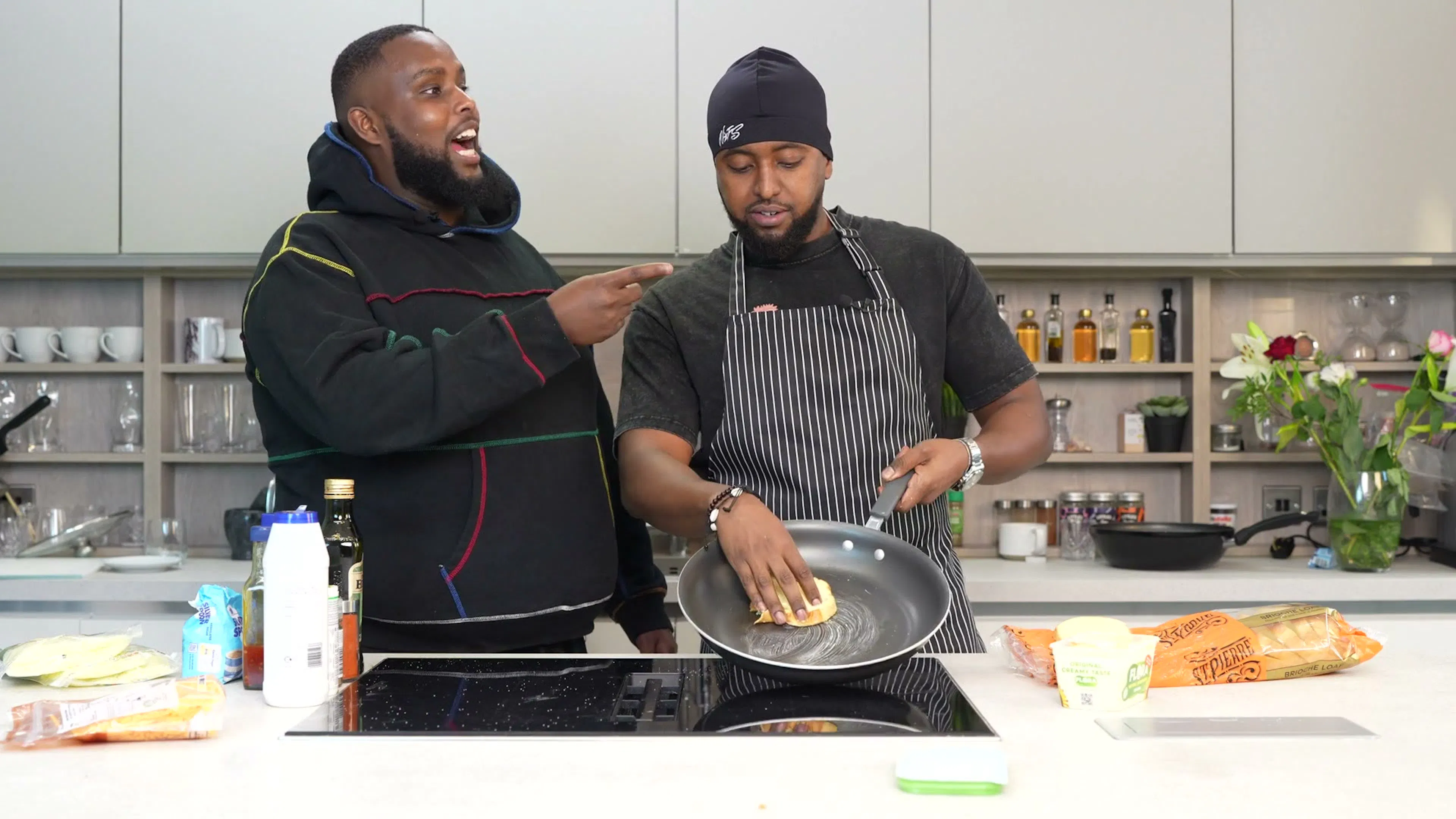 A host cooking with a guest in the bright kitchen set of Behind The Stove