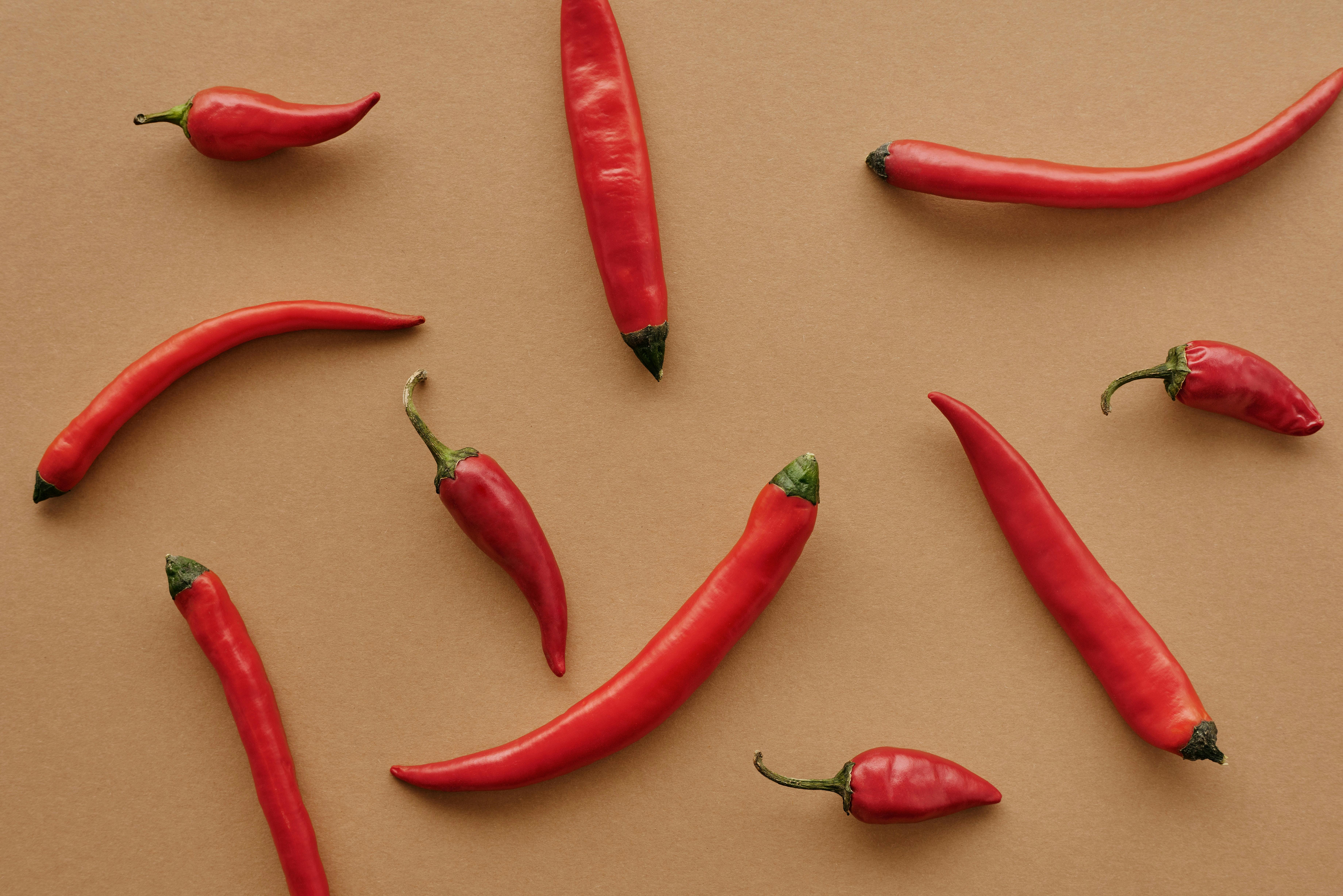 Red chilli peppers scattered on neutral background