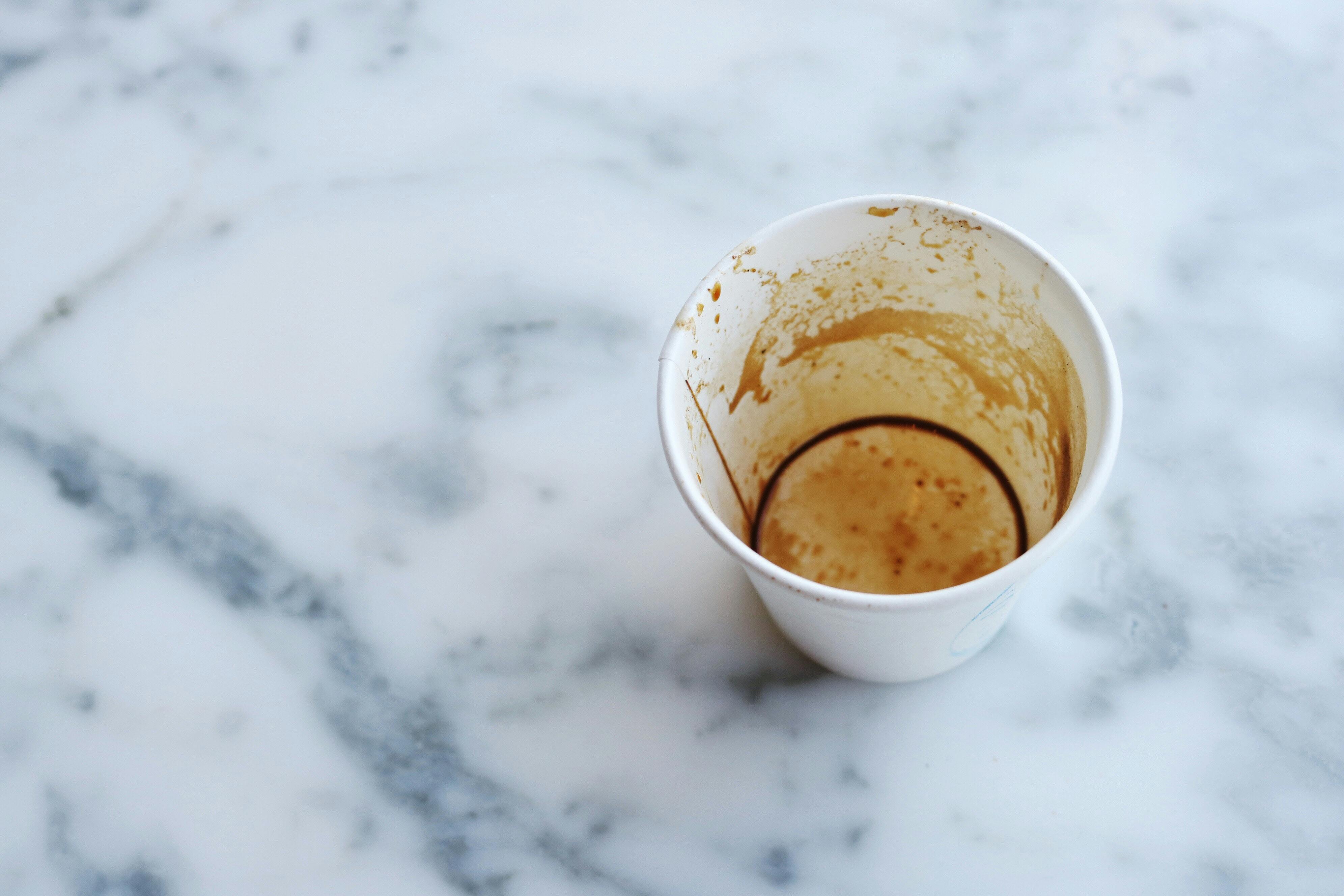 Empty paper coffee cup on grey and white marble surface