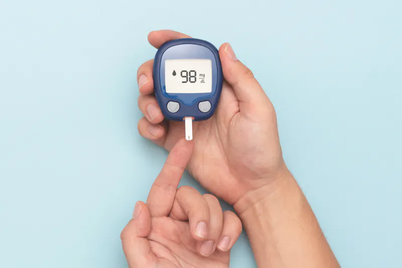 Diabetes blood sugar monitor on blue background