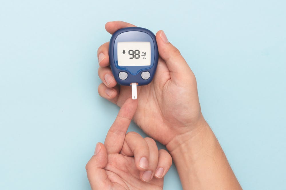 Diabetes blood sugar monitor on blue background