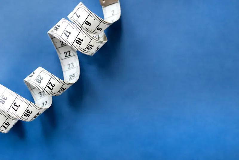 White tape measure on blue background