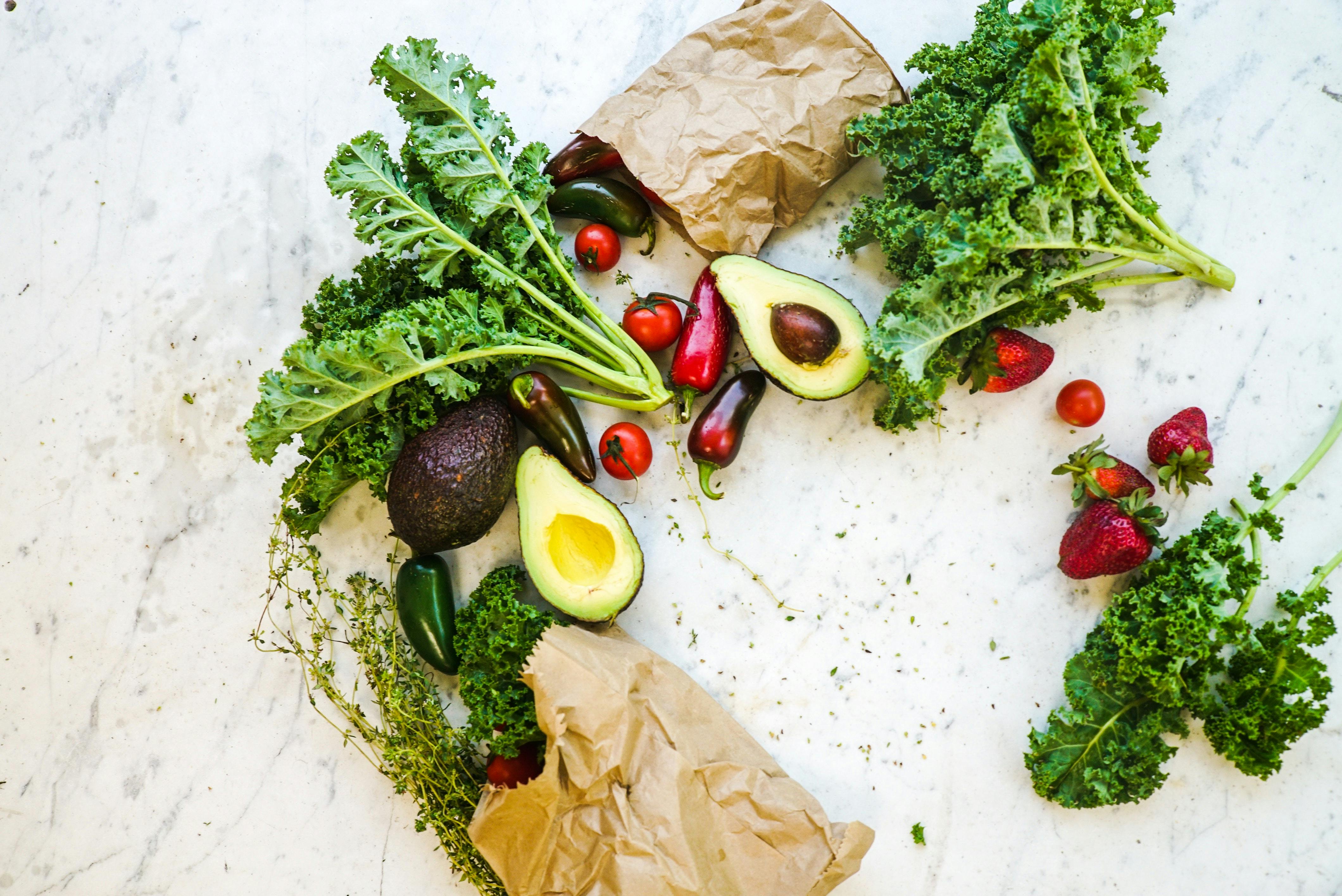 Fruit and vegetables — kale, avocados, strawberries, and tomatoes