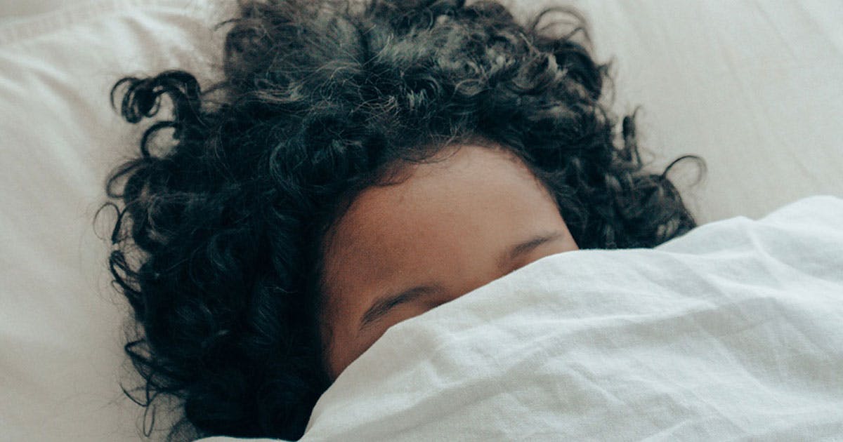 Woman with duvet cover over her face