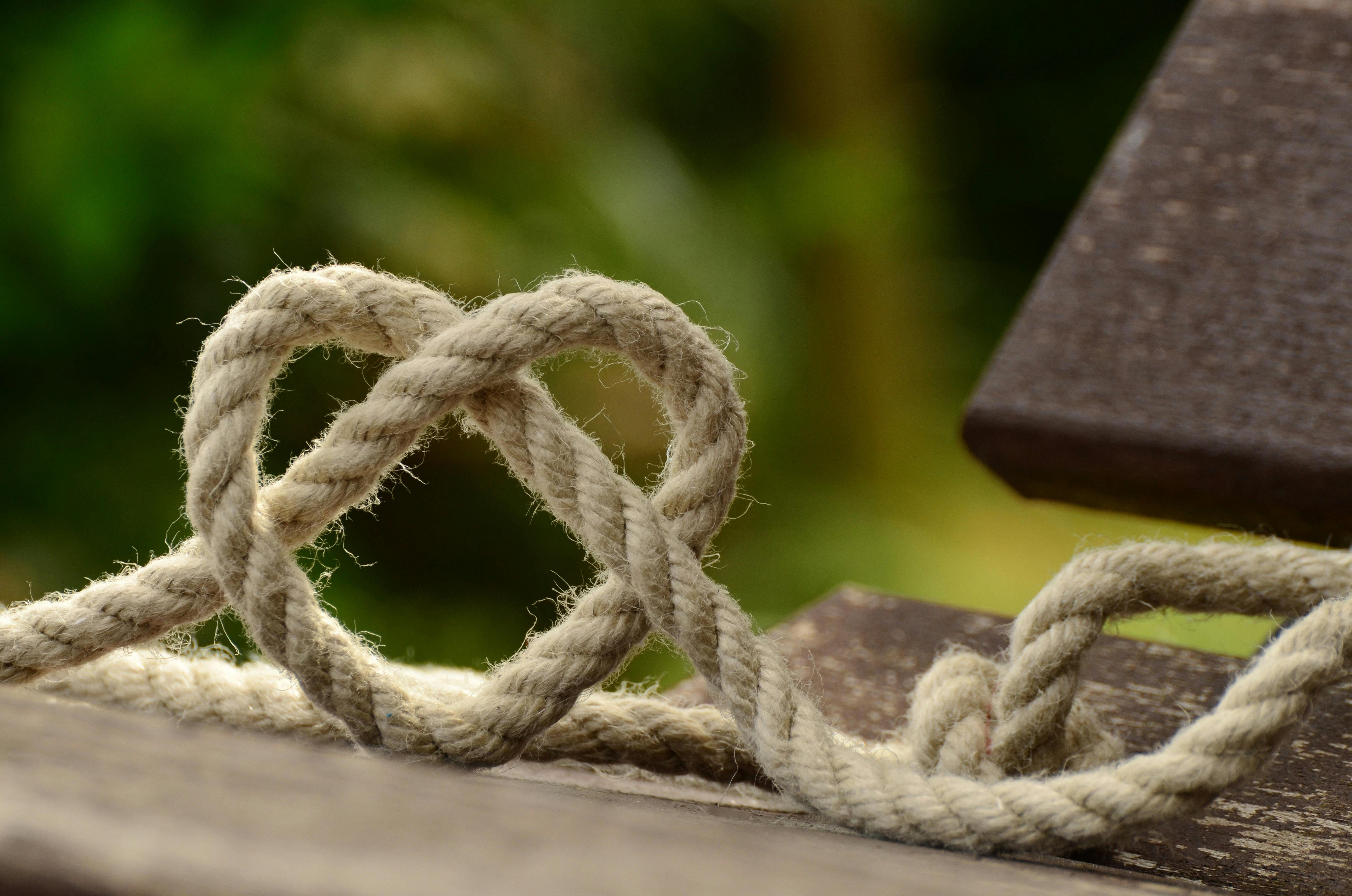 Rope tied in heart-shaped knot on park bench