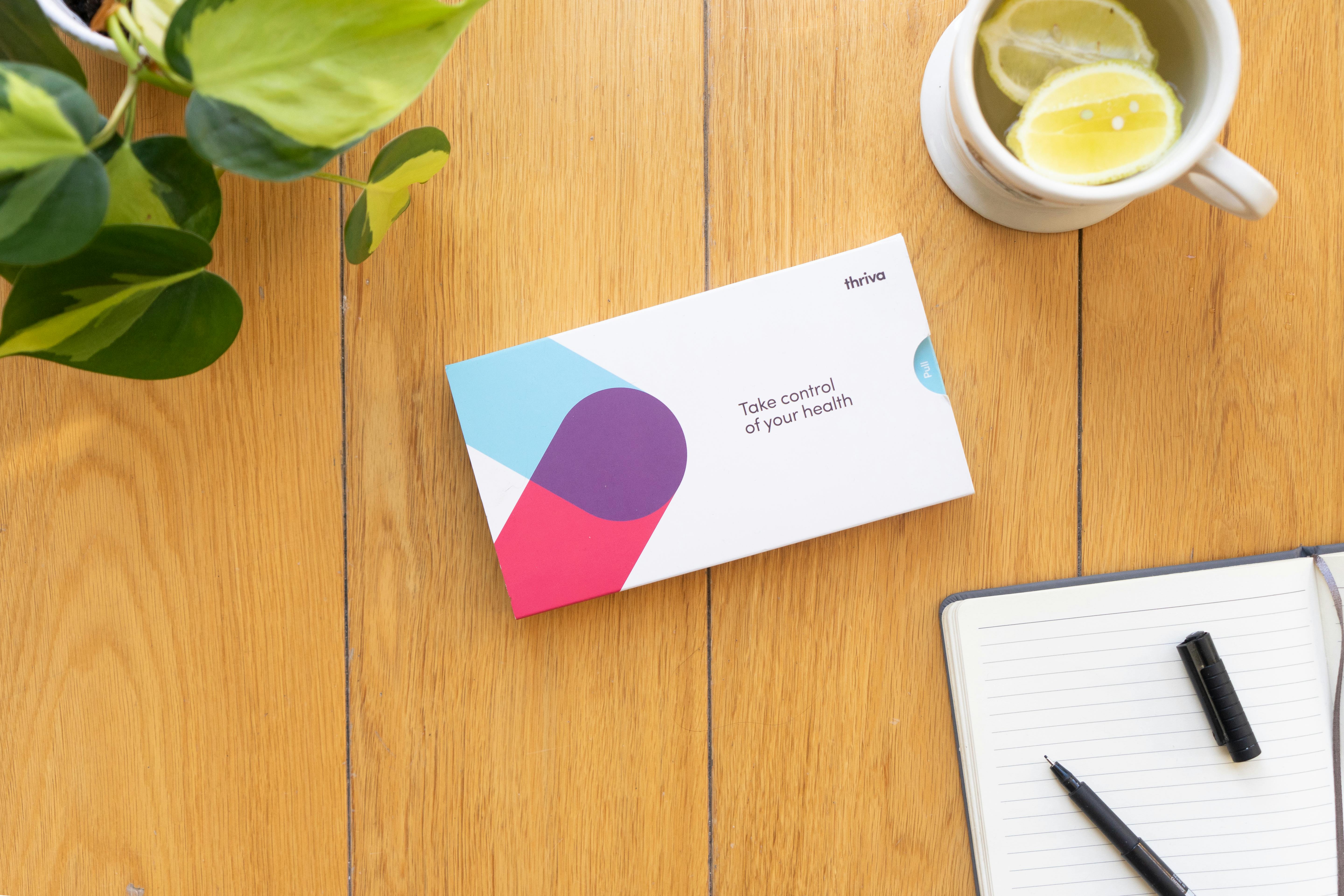 Thriva blood test kit next to lemon tea and diary