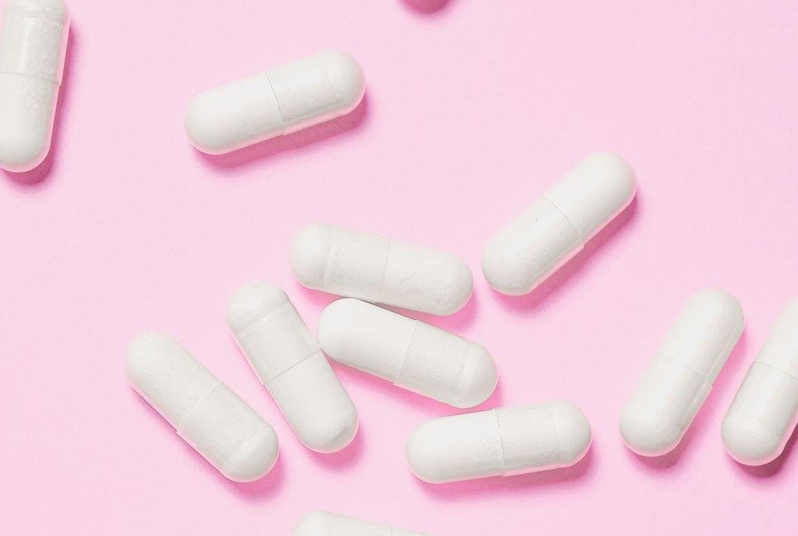 vitamin supplements on pink background 