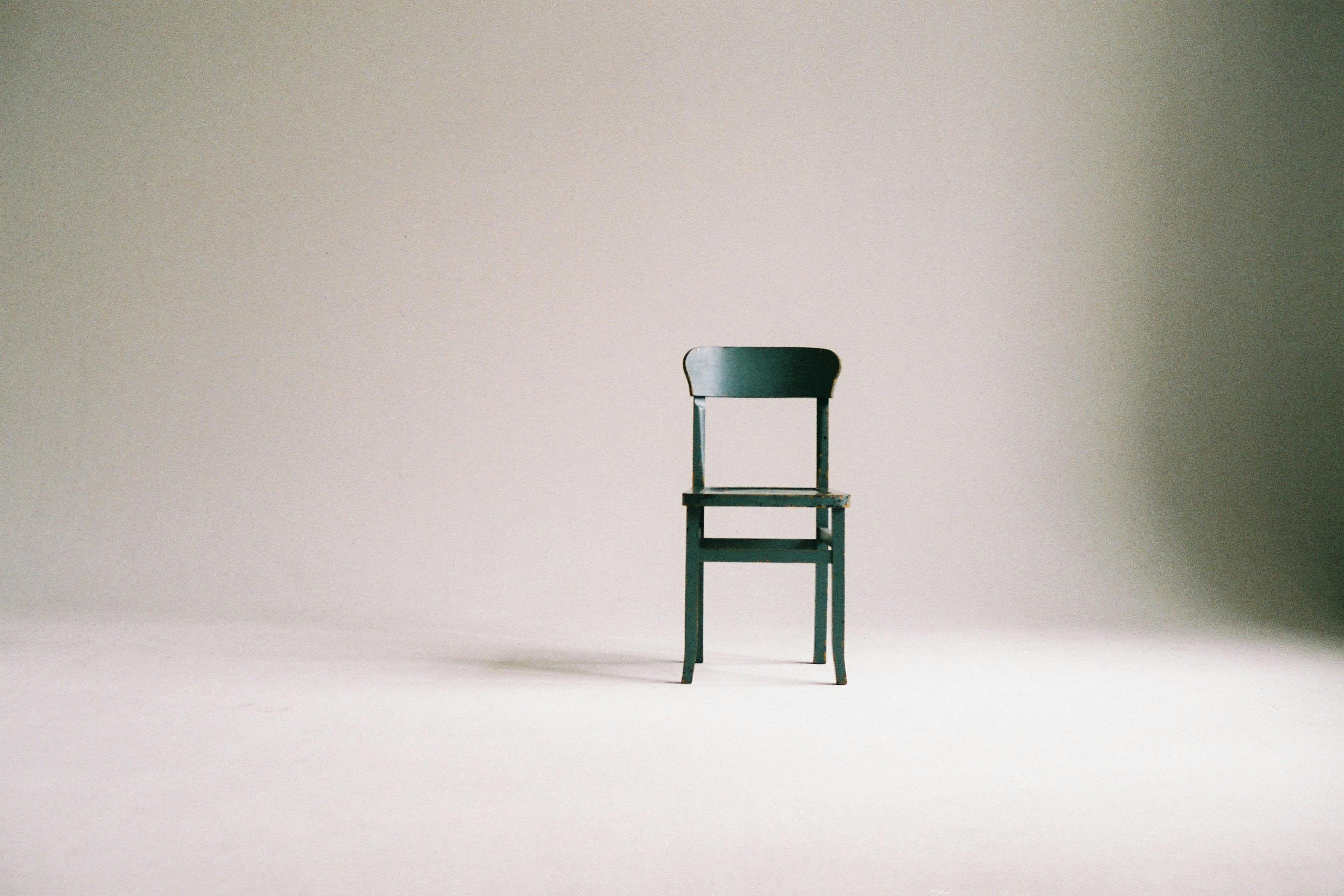 Empty green chair against white background