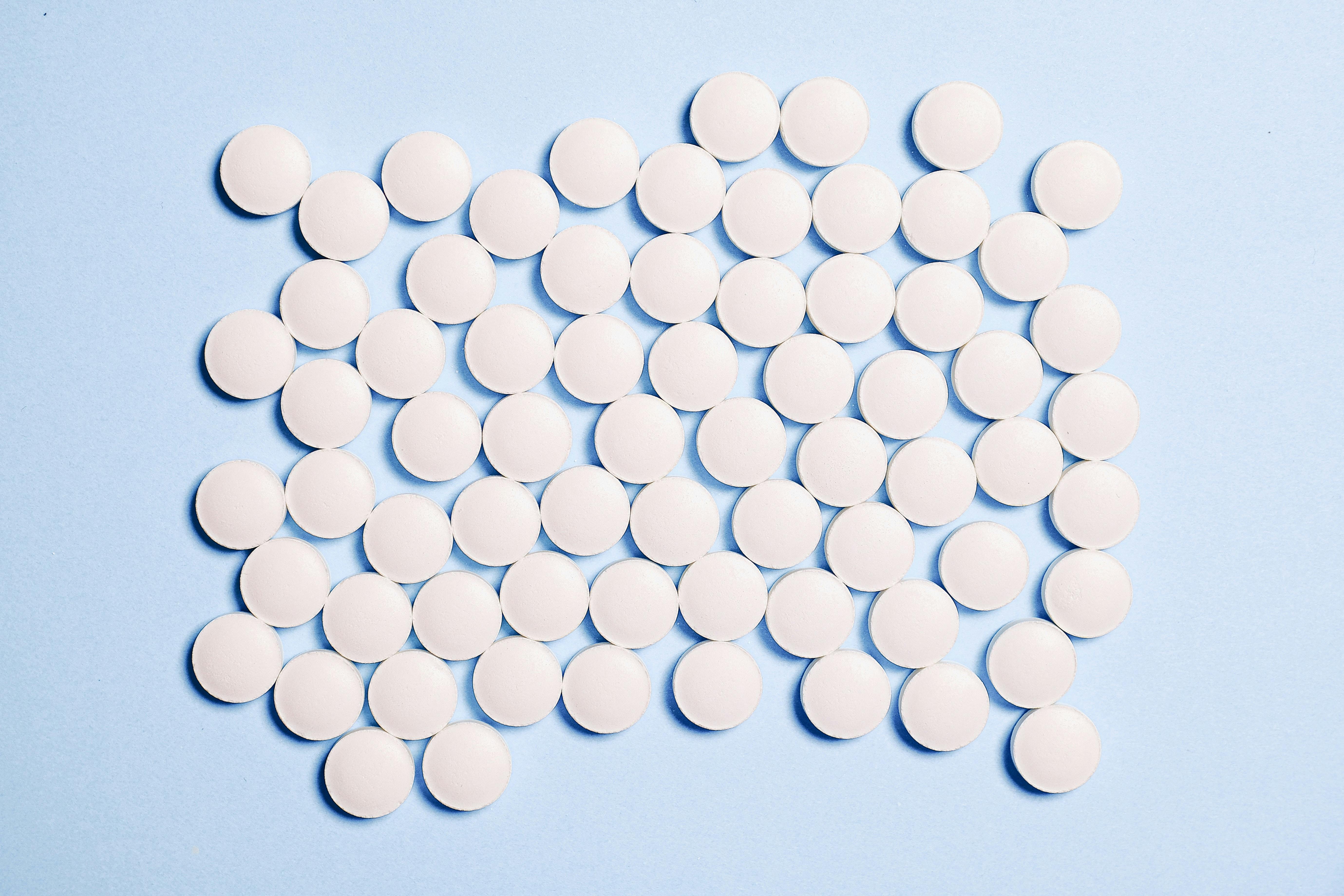 Hormone replacement therapy (HRT) tablets on blue background