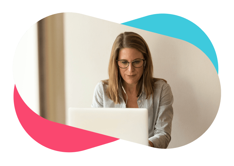 Woman with glasses typing on laptop