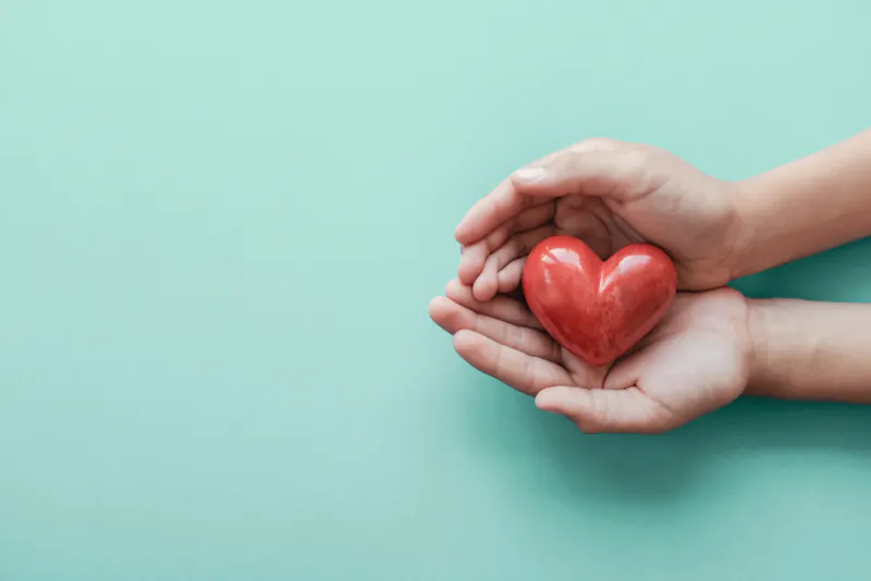 Hands holding a heart ornament
