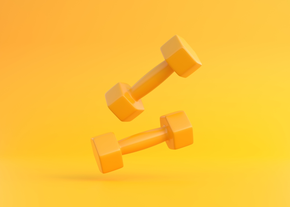 Weights floating in the air on yellow background