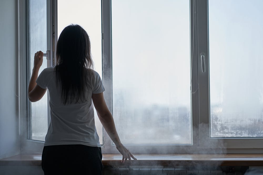 Woman opening window to let heat out