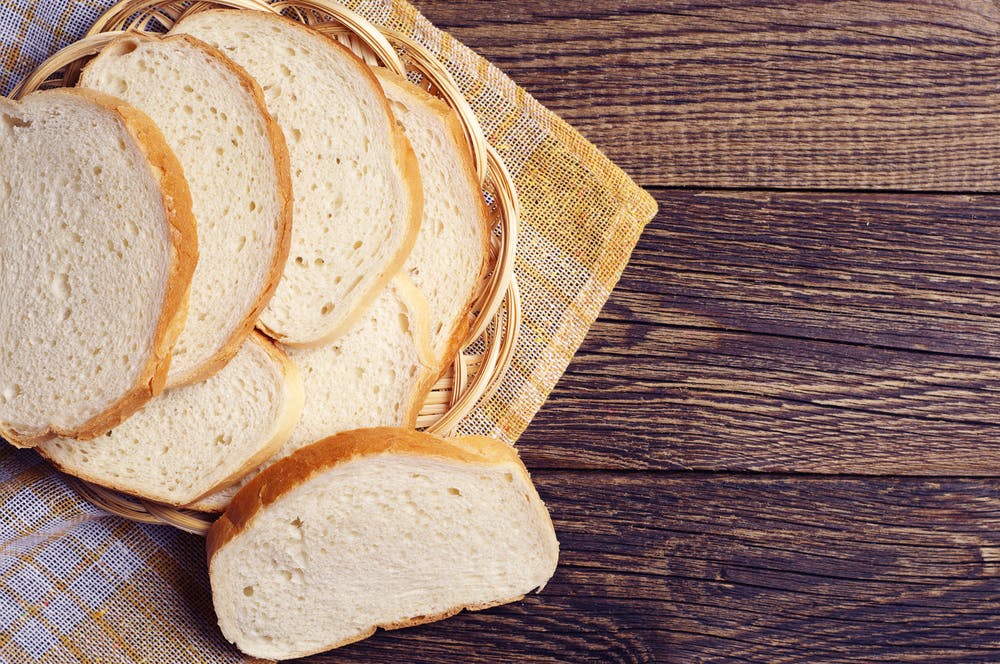 Pile of sliced white bread on a wooden chopping block