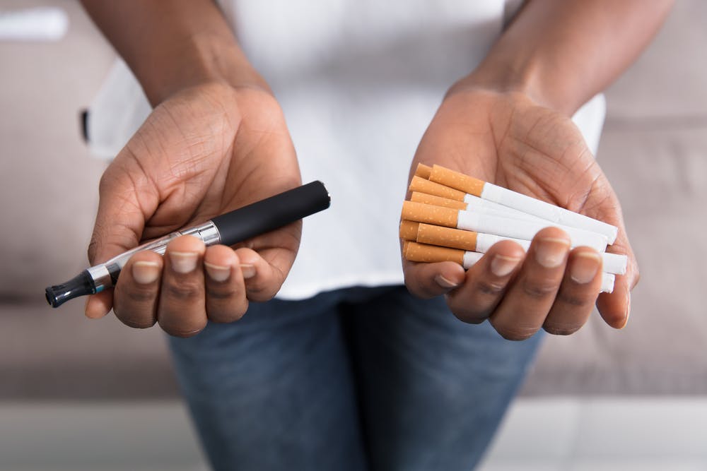 E-cigarette and cigarettes in hands