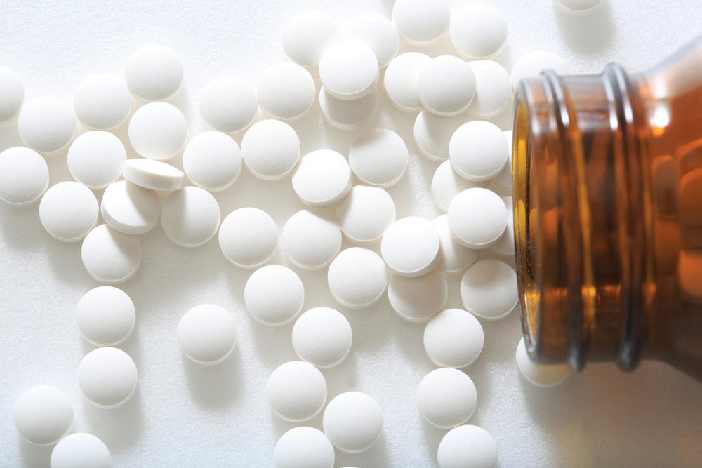Medication spilling out of pot onto white surface