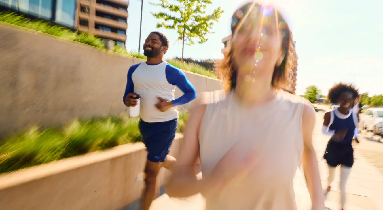 A group of three people running outside. 
