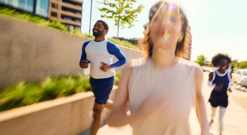 A group of three people running outside.