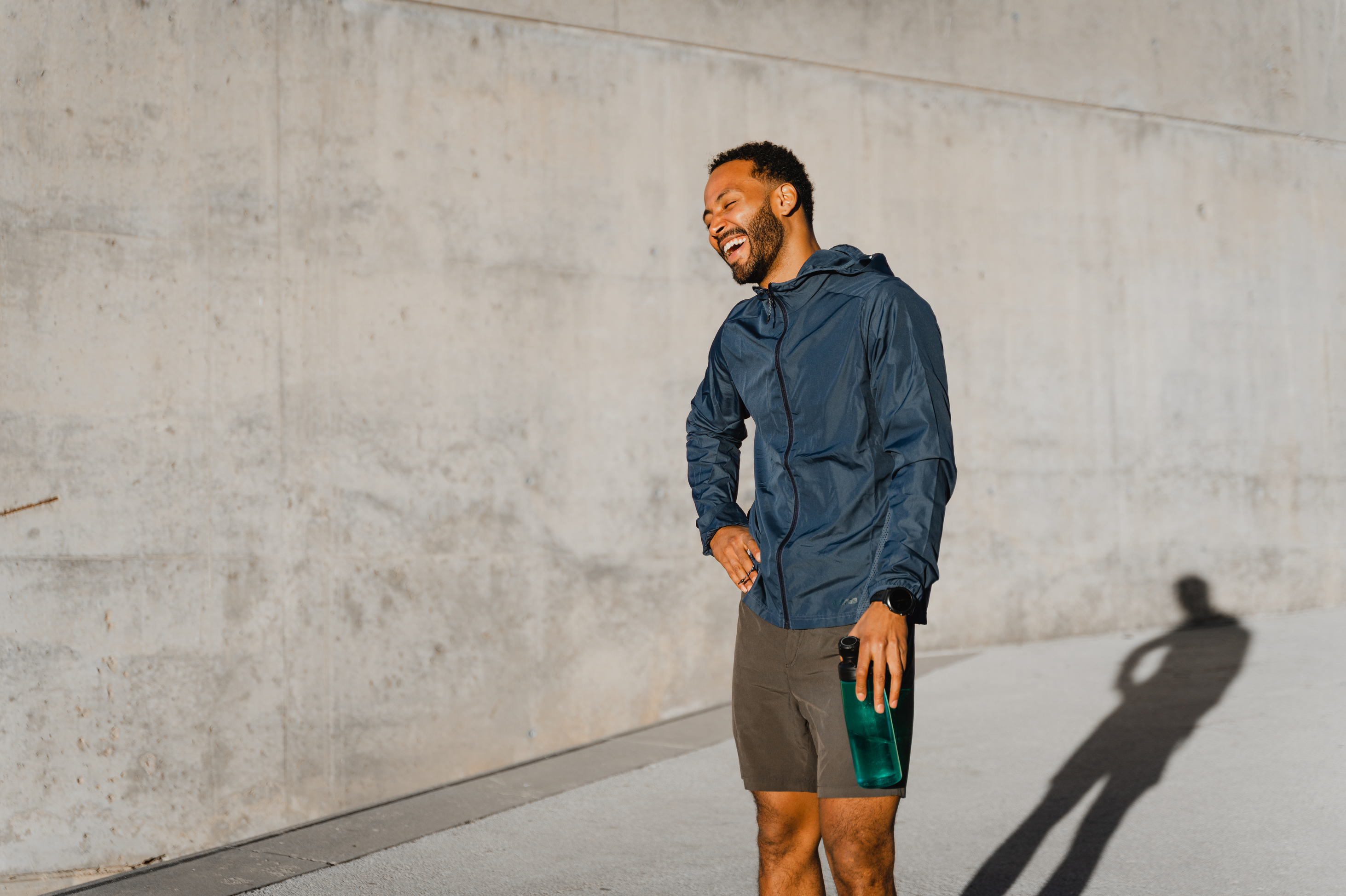 A man smiling whilst holding a water bottle