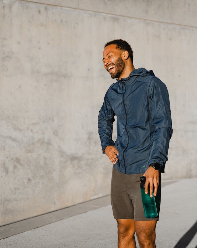 A man smiling whilst holding a water bottle